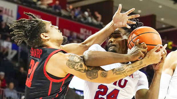 Houston Cougars guard Emanuel Sharp and SMU Mustangs guard Emory Lanier battle for the loose ball during the second half at Moody Coliseum.